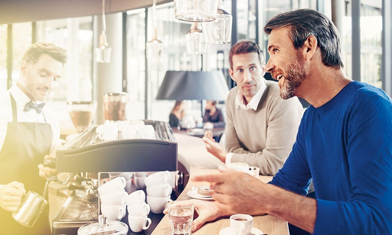 Man talking to barista at coffee shop 